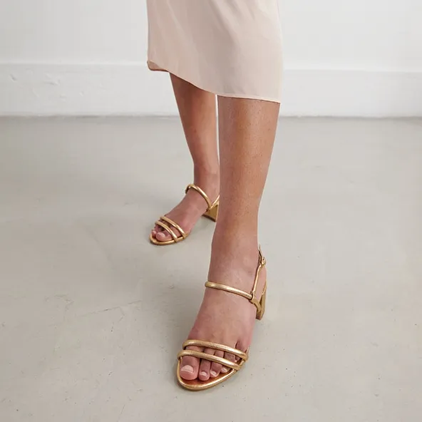 Heeled sandals in gold metallic leather